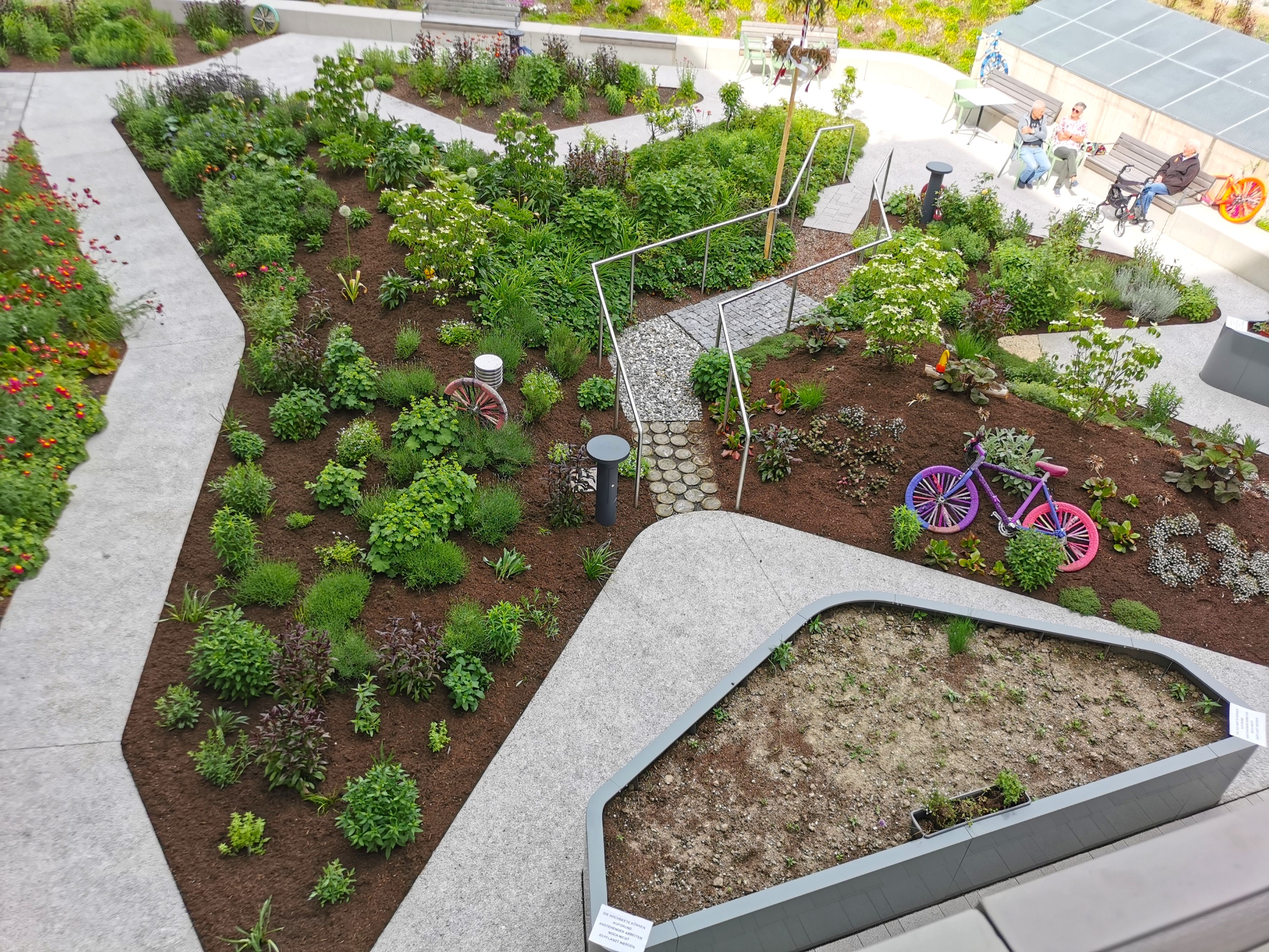 Bunter Garten mit Hochbeeten, Wegen und kreativ gestalteten Elementen – Preisträgerprojekt Silberhoamat, Best Practice Award 2024.