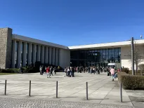 Freie Universität Berlin bei strahlendem Sonnenschein – Studierende tummeln sich vor dem modernen Hörsaalgebäude in entspannter Campus-Atmosphäre.
