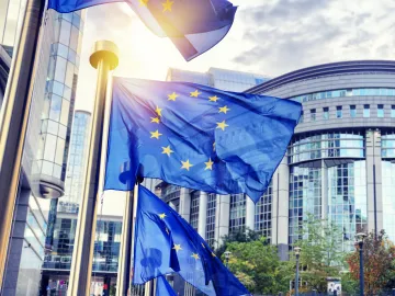 EU-Flaggen wehen vor dem modernen Gebäude des Europäischen Parlaments in Brüssel – Symbol für europäische Zusammenarbeit und digitale Gesundheitsreformen wie den Europäischen Gesundheitsdatenraum (EHDS).