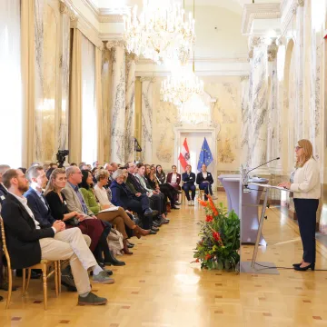 Staatssekretärin Ulrike Königsberger-Ludwig spricht bei der Preisverleihung des Best Practice Award „Klimafreundliche Gesundheitseinrichtungen“ 2025 vor den teilnehmenden Gesundheitseinrichtungen im Festsaal des Ministeriums.