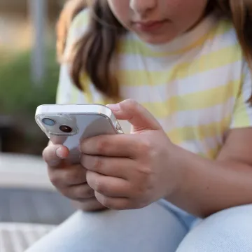 Kind oder Jugendliche bedient ein Smartphone.