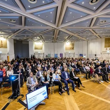 Blick in den prall gefüllten Veranstaltungssaal bei der Verleihung des Österreichischen Verwaltungspreises 2025. Zahlreiche Gäste aus Verwaltung, Politik und Organisationen verfolgen die Preisverleihung.