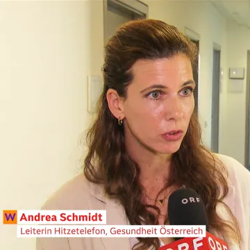 Screenshot eines ORF-Interviews: Eine Frau spricht in einem Bürogebäude in ein ORF-Mikrofon. Die Bauchbinde lautet „Andrea Schmidt – Leiterin Hitzetelefon, Gesundheit Österreich“. Der Beitrag in „Wien heute“ trägt den Titel „Hitzetelefon bietet Rat zu Gesundheit und Hitze“.