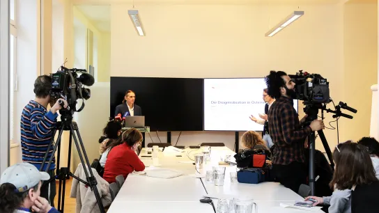 Pressekonferenz zur Drogensituation in Österreich – Martin Busch präsentiert aktuelle Daten, Journalist:innen und Kamerateams dokumentieren die Veranstaltung.