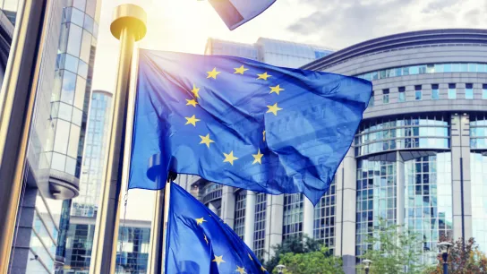 © Symbiot - stock.adobe.com EU-Flaggen wehen vor dem modernen Gebäude des Europäischen Parlaments in Brüssel – Symbol für europäische Zusammenarbeit und digitale Gesundheitsreformen wie den Europäischen Gesundheitsdatenraum (EHDS).