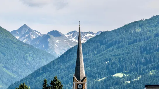 Kirchturm von Bad Hofgastein vor Alpenkulisse – Veranstaltungsort des European Health Forum Gastein 2025.