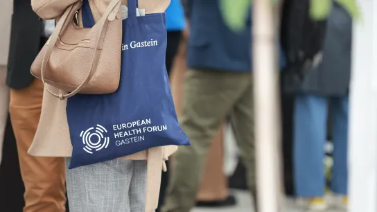 Person hat Jutebeutel mit Logo vom European Health Forum 2025 in Bad Hofgastein umgehängt.