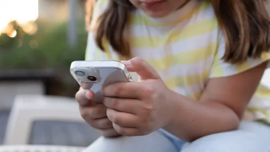 Kind oder Jugendliche bedient ein Smartphone.